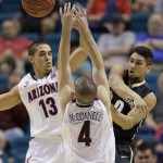 Colorado's Askia Booker, right, passes off the ball against Arizona's Nick Johnson and Arizona's T.J. McConnell during the first half of an NCAA college basketball game in the semifinals of the Pac-12 Conference on Friday, March 14, 2014, in Las Vegas. (AP Photo/Julie Jacobson)