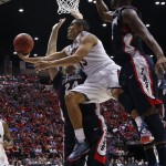 Arizona guard Nick Johnson, center, looks to pass as he is guarded by Gonzaga center Przemek Karnowski, left, and guard Gary Bell, Jr., right, during the first half of a third-round game in the NCAA college basketball tournament Sunday, March 23, 2014, in San Diego. (AP Photo/Lenny Ignelzi)