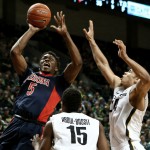 Arizona forward Stanley Johnson shoots over Oregon guard Jalil Abdul-Bassit, center, and forward Dillon Brooks, right, during the first half of an NCAA college basketball game Thursday, Jan. 8, 2015, in Eugene, Ore. (AP Photo/Ryan Kang)