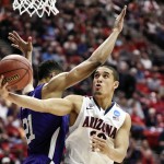 Arizona's Nick Johnson gets a shot off under the arm of Weber State's Joel Bolomboy during the second half in a second-round game in the NCAA college basketball tournament Friday, March 21, 2014, in San Diego. (AP Photo/Denis Poroy)