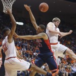 Arizona's Brandon Ashley, center, loses control of the ball as he attempts to score between UTEP defenders Vince Huner, left, and Cedrick Lang during the first half of an NCAA college basketball game Friday, Dec. 19, 2014, in El Paso, Texas. (AP Photo/Victor Calzada)