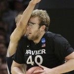 Xavier center Matt Stainbrook, right, takes an arm to the face from Arizona center Kaleb Tarczewski during the first half of a college basketball regional semifinal in the NCAA Tournament, Thursday, March 26, 2015, in Los Angeles. (AP Photo/Jae C. Hong)