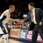 Arizona guard T.J. McConnell, left, and coach Sean Miller celebrate after a play against Southern California during the first half of an NCAA college basketball game, Thursday, Feb. 19, 2015, in Tucson, Ariz. (AP Photo/Rick Scuteri)