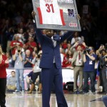 Former Arizona player Jason Terry holds up his jersey after his number was retired during an NCAA college basketball game between Southern California and Arizona, Thursday, Feb. 19, 2015, in Tucson, Ariz. (AP Photo/Rick Scuteri)