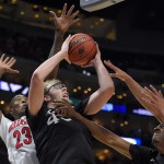 Xavier center Matt Stainbrook, center, shoots as Arizona forward Rondae Hollis-Jefferson, left, defends during the first half of a college basketball regional semifinal in the NCAA Tournament, Thursday, March 26, 2015, in Los Angeles. (AP Photo/Mark J. Terrill)