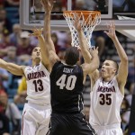 Colorado's Josh Scott (40) shoots against Arizona's Nick Johnson (13) and Arizona's Kaleb Tarczewski (35) during the first half of an NCAA college basketball game in the semifinals of the Pac-12 Conference on Friday, March 14, 2014, in Las Vegas. (AP Photo/Julie Jacobson)