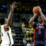  Arizona forward Stanley Johnson, right, shoots over Oregon guard Jalil Abdul-Bassit during the first half of an NCAA college basketball game Thursday, Jan. 8, 2015, in Eugene, Ore. (AP Photo/Ryan Kang)