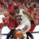 Arizona's Solomon Hill (44) loses control of the ball as he is sandwiched between Southern California's Ari Steward, left, and Dewayne Dedmon, right, during the first half of an NCAA basketball game at McKale Center in Tucson, Ariz., Jan. 26, 2013. (AP Photo/John Miller)
