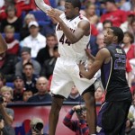 Arizona's Solomon Hill (44) passes the ball away from the defense of Washington's C.J. Wilcox (23) during the second half of an NCAA college basketball game at McKale Center in Tucson, Ariz., Wednesday, Feb. 20, 2013. Arizona won 70 -52. (AP Photo/John Miller)
