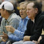 John Elway, center, executive vice president of football operations for the Denver Broncos, takes a courtside seat to watch Colorado host Arizona in the first half of an NCAA college basketball game in Boulder, Colo., on Thursday, Feb. 14, 2013. (AP Photo/David Zalubowski)