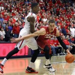 Stanford's Dwight Powell (33) tries to dribble around the defense of Arizona's Rondae Hollis-Jefferson during the first half of an NCAA college basketball game Sunday, March 2, 2014, in Tucson, Ariz. (AP Photo/John MIller)