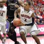 Arizona's Mark Lyons (2) looks to pass while being defended by Washington's C.J. Wilox (23) during the first half of an NCAA college basketball game at McKale Center in Tucson, Ariz., Wednesday, Feb. 20, 2013. (AP Photo/John Miller)