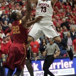 Arizona's Nick Johnson (13) shoots for two points over the attempted defense of Southern California's Byron Wesley (22) during the first half of an NCAA basketball game at McKale Center in Tucson, Ariz., Jan. 26, 2013. (AP Photo/John Miller)
