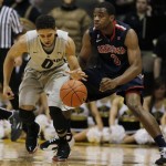 Colorado guard Askia Booker, left, picks up a loose ball as Arizona guard Kevin Parrom covers in the first half of an NCAA college basketball game in Boulder, Colo., Thursday, Feb. 14, 2013. (AP Photo/David Zalubowski)