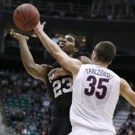 Harvard's Wesley Saunders, left, has his shot blocked by Arizona's Kaleb Tarczewski during the first half during a third-round game in the NCAA men's college basketball tournament in Salt Lake City Saturday, March 23, 2013. (AP Photo/George Frey)
