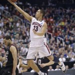 Arizona's Nick Johnson (13) lays the ball up next to Harvard's Christian Webster in the first half during a third-round game in the NCAA men's college basketball tournament in Salt Lake City, Saturday, March 23, 2013. (AP Photo/Rick Bowmer)
