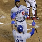 Los Angeles Dodgers' Carl Crawford (25) is greeted at home plate by Matt Kemp (27) after scoring on a base hit by Adrian Gonzalez against the Arizona Diamondbacks during the fourth inning of a baseball game, Wednesday, Sept. 18, 2013, in Phoenix. (AP Photo/Matt York)
