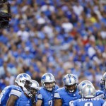 
              FILE - In this Sept. 8, 2014, file photo, a cable camera hangs above a Detroit Lions huddle during an NFL football game against the New York Giants at Ford Field in Detroit. For athletes across all sports, it's become a way of life as the primary focus has shifted from fans watching in person to fans at home and in the sports bars watching on television. The camera is always watching, there are few places to hide and they have come to accept them as a part of their world from the moment they arrive for work.  (AP Photo/Rick Osentoski, File)
            