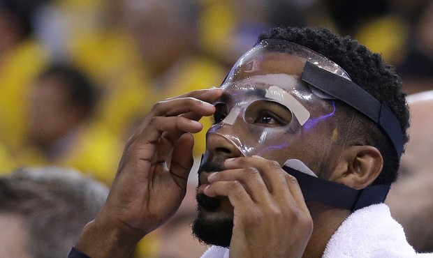 FILE – In this May 5, 2015, file photo, Memphis Grizzlies guard Mike Conley adjusts his mask ...