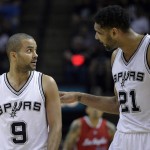 
              San Antonio Spurs' Tony Parker (9) talks with teammate Tim Duncan (21) during the first half of Game 3 in an NBA basketball first-round playoff series against the Los Angeles Clippers, Friday, April 24, 2015, in San Antonio. (AP Photo/Darren Abate)
            
