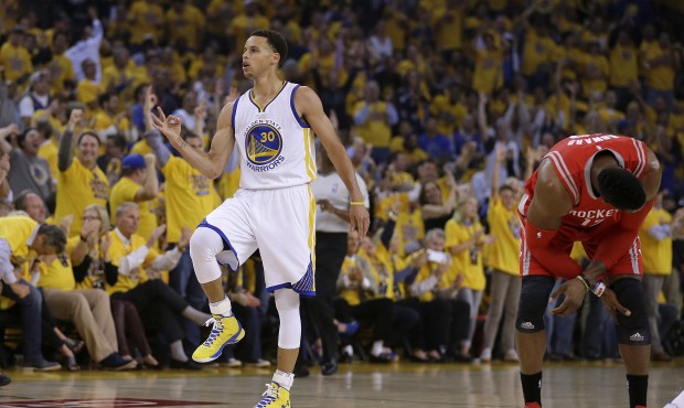 Golden State Warriors’ Stephen Curry, left, celebrates beside Houston Rockets’ Dwight H...