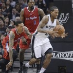 
              San Antonio Spurs' Kawhi Leonard (2) grabs a loose ball in front of Los Angeles Clippers' Matt Barnes, left, and DeAndre Jordan (6) during the first half of Game 3 in an NBA basketball first-round playoff series, Friday, April 24, 2015, in San Antonio. (AP Photo/Darren Abate)
            
