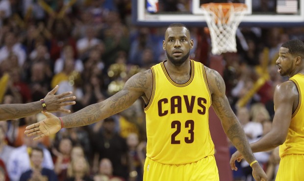 Cleveland Cavaliers forward LeBron James slaps hands with a teammate after scoring against the Chic...