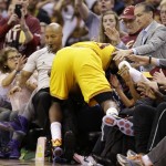 
              Cleveland Cavaliers forward LeBron James (23) crashes into referee Marc Davis and fans as he goes for a loose ball against the Golden State Warriors during the second half of Game 3 of basketball's NBA Finals in Cleveland, Tuesday, June 9, 2015. (AP Photo/Tony Dejak)
            