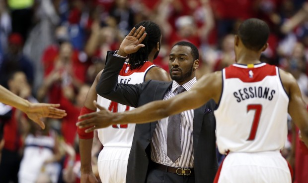 Washington Wizards guard John Wall, in suit, celebrates with guard Ramon Sessions (7) during a brea...