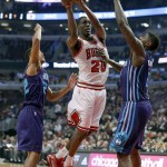 Chicago Bulls forward Tony Snell (20) drives between Charlotte Hornets guard Brian Roberts (22) and Marvin Williams during the first half of an NBA basketball game Wednesday, Feb. 25, 2015, in Chicago. (AP Photo/Charles Rex Arbogast)