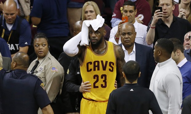 Cleveland Cavaliers forward LeBron James (23) holds a towel to his head after being knocked into th...