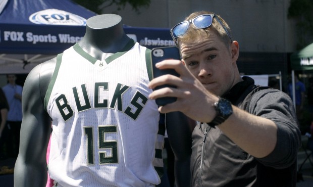A fan poses with a new Milwaukee Bucks basketball jersey at a summer block party Saturday, June 6, ...
