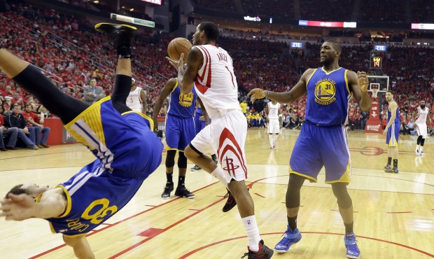 Golden State Warriors guard Stephen Curry (30) topples over Houston Rockets forward Trevor Ariza (1...