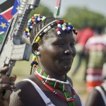 
              A South Sudanese woman wears the national flag and carries a mock gun as she attends an independence day ceremony in the capital Juba, South Sudan, Thursday, July 9, 2015. South Sudan marked four years of independence from Sudan on Thursday, but the celebrations were tempered by concerns about ongoing violence and the threat of famine. (AP Photo/Jason Patinkin)
            