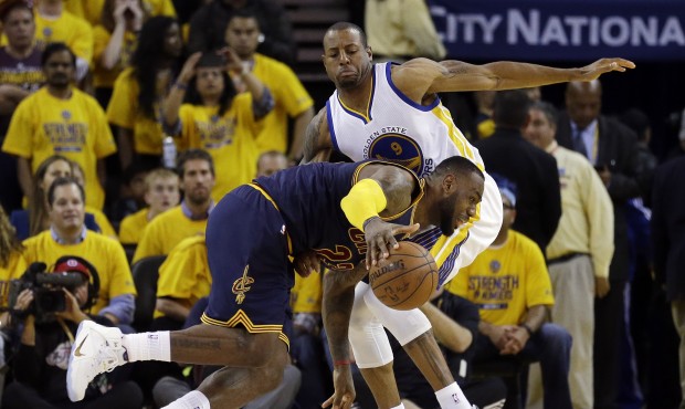 Cleveland Cavaliers forward LeBron James, bottom, drives against Golden State Warriors forward Andr...