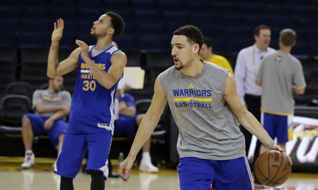 Golden State Warriors’ Klay Thompson, right, drives the ball behind Stephen Curry (30) during...