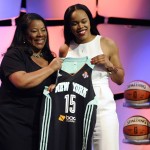 
              FILE - In this April 16, 2015, file photo, California’s Brittany Boyd holds up a New York Liberty jersey with WNBA president Laurel J. Richie after the Liberty selected Boyd in the WNBA basketball draft in Uncasville, Conn. Richie hopes that with the league's 19th season beginning Friday, June 5, the attention will turn to the play on the court instead of the news off of it. (AP Photo/Jessica Hill, File)
            
