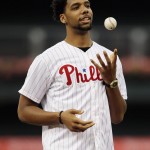 
              FILE - In this June 30, 2015, file photo, Philadelphia 76ers draft pick Jahlil Okafor tosses a ball as he waits to throw out the ceremonial first pitch before a baseball game between the Philadelphia Phillies and the Milwaukee Brewers in Philadelphia. Summer leagues begin this weekend in Orlando, Florida, games in Salt Lake City set to tip-off on Monday and the 24-team fan-friendly event in Las Vegas opening on July 10. (AP Photo/Matt Slocum, File)
            