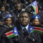 
              A South Sudanese police officer sits with his uniform covered with national flags, as he attends an independence day ceremony in the capital Juba, South Sudan, Thursday, July 9, 2015. South Sudan marked four years of independence from Sudan on Thursday, but the celebrations were tempered by concerns about ongoing violence and the threat of famine. (AP Photo/Jason Patinkin)
            