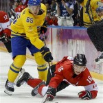 Canada forward Jonathan Toews dives after the puck against Sweden defenseman Erik Karlsson during the third period of the men's gold medal ice hockey game at the 2014 Winter Olympics, Sunday, Feb. 23, 2014, in Sochi, Russia. (AP Photo/Matt Slocum)