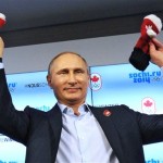 Russian President Vladimir Putin shows handmade mittens presented to him at Canada House during the 2014 Winter Olympics, Friday, Feb. 14, 2014 in Sochi, Russia. At left is Chairman of the Canadian National Olympic Committee Marcel Aubut. (AP Photo /RIA-Novosti, Mikhail Klimentyev, Presidential Press Service)