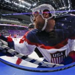 USA forward Phil Kessel crashes the boards against Canada during the second period of a men's semifinal ice hockey game at the 2014 Winter Olympics, Friday, Feb. 21, 2014, in Sochi, Russia. (AP Photo/Petr David Josek)
