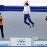 Silver medallist Ireen Wust of the Netherlands, left, and bronze medallist Carien Kleibeuker of the Netherlands, right, applaud gold medallist Martina Sablikova of the Czech Republic as she jumps for joy during the flower ceremony for the women's 5,000-meter speedskating race at the Adler Arena Skating Center during the 2014 Winter Olympics in Sochi, Russia, Wednesday, Feb. 19, 2014. (AP Photo/Matt Dunham)