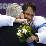 Teemu Selanne of Finland (8) hugs the presenter after receiving his medal after the men's bronze medal ice hockey game at the 2014 Winter Olympics, Saturday, Feb. 22, 2014, in Sochi, Russia. (AP Photo/Julio Cortez)