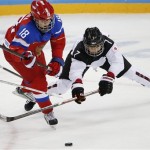 Olga Sosina of Russia and Mika Hori of Japan battle for control of the puck during the 2014 Winter Olympics women's ice hockey game at Shayba Arena Sunday, Feb. 16, 2014, in Sochi, Russia. (AP Photo/Petr David Josek)