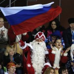 A man dressed as Ded Moroz, the Russian Santa Claus, waves the Russian flag while cheering for the home team during women's curling competition against China at the 2014 Winter Olympics, Tuesday, Feb. 11, 2014, in Sochi, Russia. (AP Photo/Robert F. Bukaty)