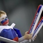 A Russian boy's is painted in the colors of the Russian national flag as he cheers the Russian women's curling team on with thunder sticks as they compete against Denmark at the 2014 Winter Olympics, Monday, Feb. 10, 2014, in Sochi, Russia. (AP Photo/Wong Maye-E)