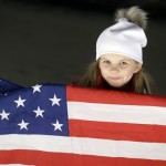 A young fan with an American flag waits for the start of the men's two-man bobsled competition at the 2014 Winter Olympics, Sunday, Feb. 16, 2014, in Krasnaya Polyana, Russia. (AP Photo/Natacha Pisarenko)