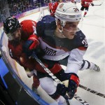 USA forward Paul Stastny and Canada defenseman Marc-Edouard Vlasic crash the boards during the first period of a men's semifinal ice hockey game at the 2014 Winter Olympics, Friday, Feb. 21, 2014, in Sochi, Russia. (AP Photo/Julio Cortez)