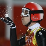 Switzerland's Simon Ammann blows snow off his hand after his second attempt during the ski jumping large hill final at the 2014 Winter Olympics, Saturday, Feb. 15, 2014, in Krasnaya Polyana, Russia. (AP Photo/Gregorio Borgia)